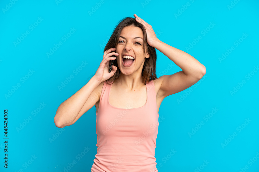 Young caucasian woman using mobile phone isolated on blue background with surprise expression Young caucasian woman using mobile phone isolated on blue background with surprise expression