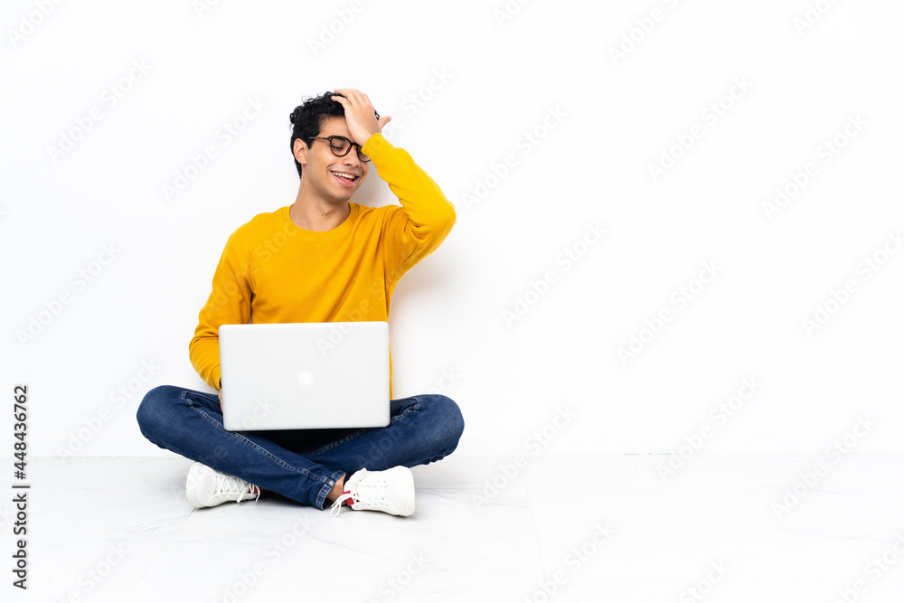 Venezuelan man sitting on the floor with laptop has realized something and intending the solution Venezuelan man sitting on the floor with laptop has realized something and intending the solution