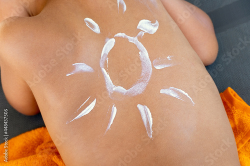 Sunscreen cream on back of small child in form of sun. Protection, from ultraviolet radiation and burns