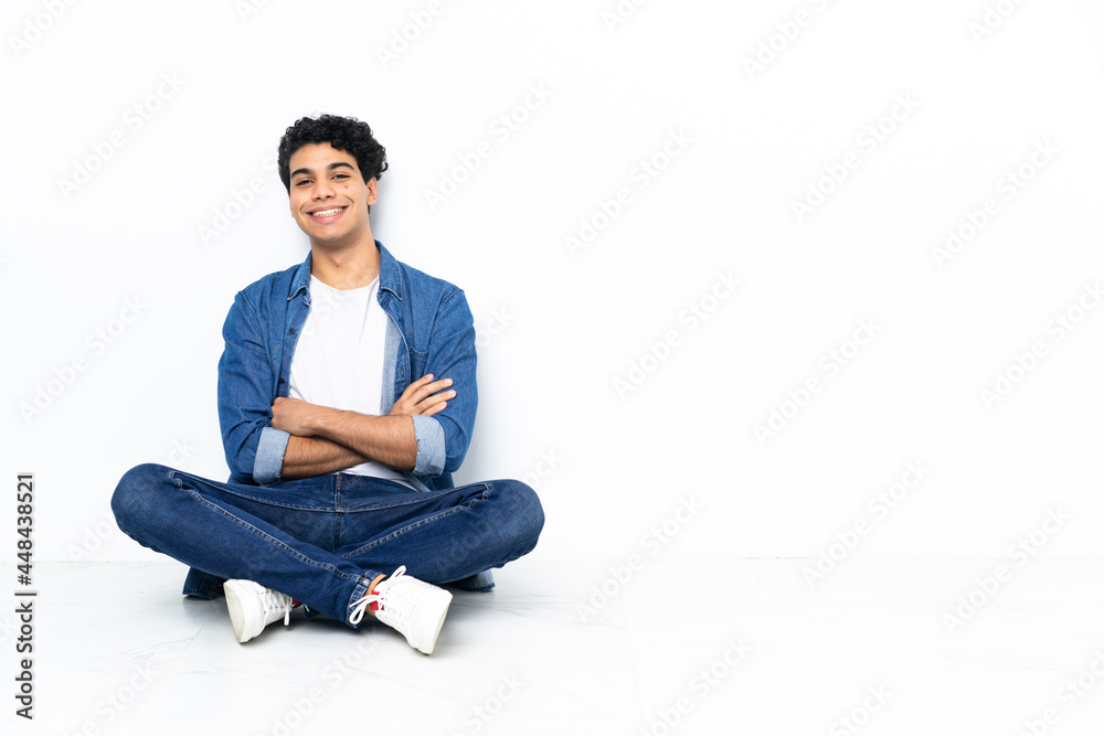 Venezuelan man sitting on the floor keeping the arms crossed in frontal position Venezuelan man sitting on the floor keeping the arms crossed in frontal position