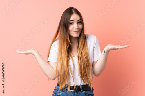 Young caucasian woman isolated on pink background having doubts while raising hands