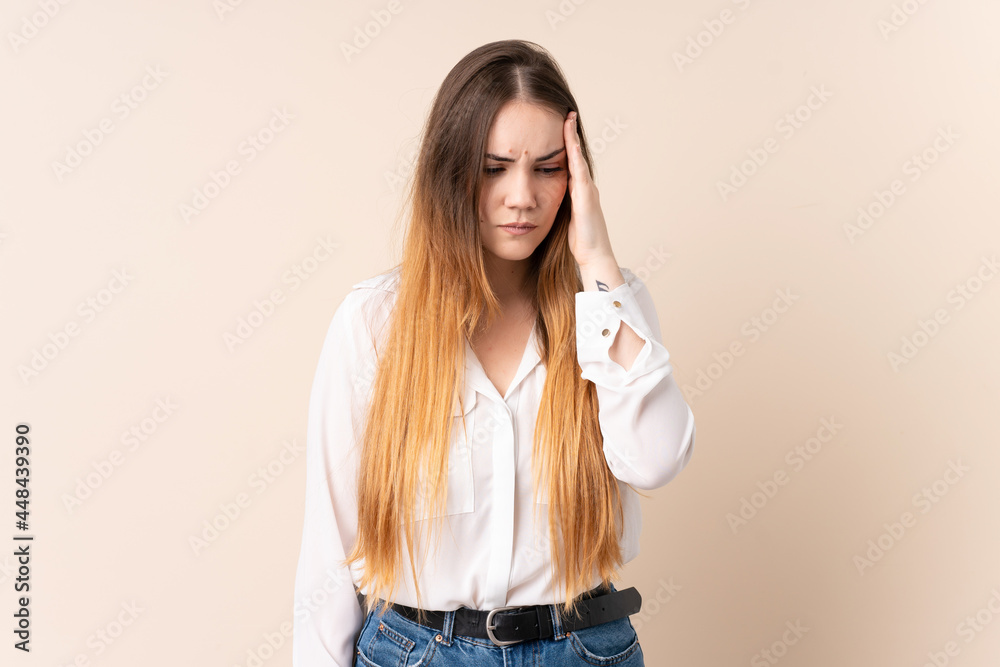 Young caucasian woman isolated on beige background with headache Young caucasian woman isolated on beige background with headache