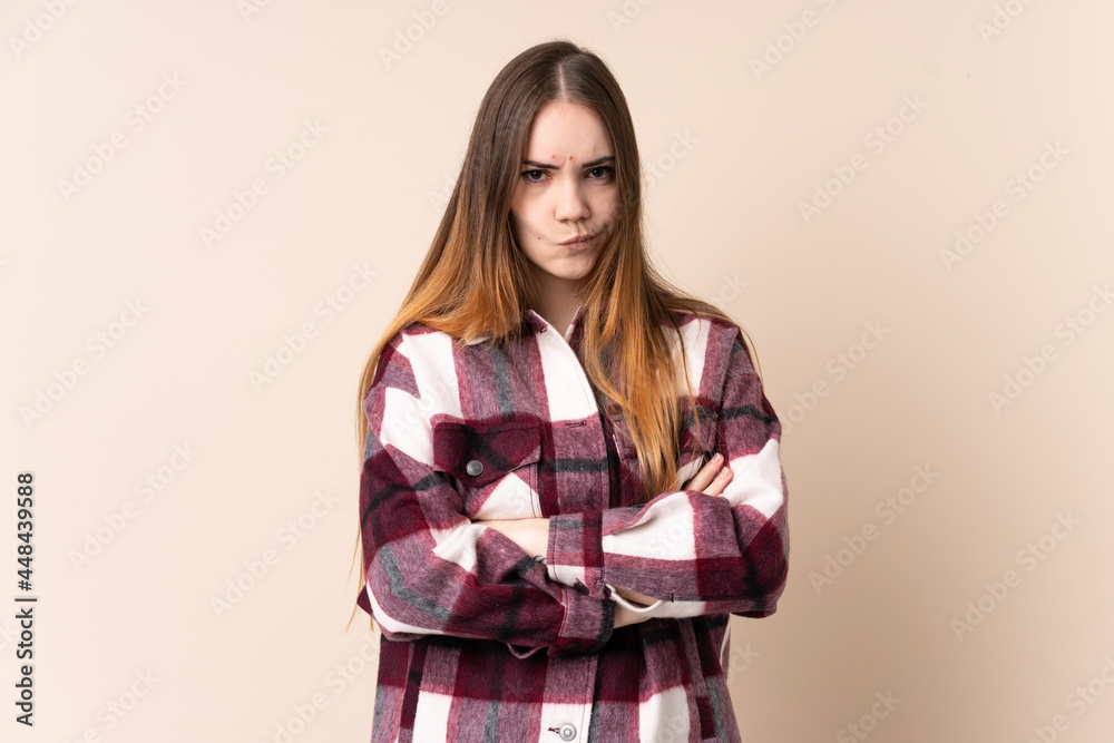 Young caucasian woman isolated on beige background with unhappy expression Young caucasian woman isolated on beige background with unhappy expression