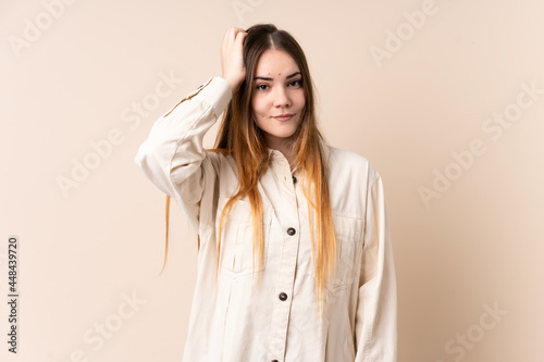 Young caucasian woman isolated on beige background with an expression of frustration and not understanding