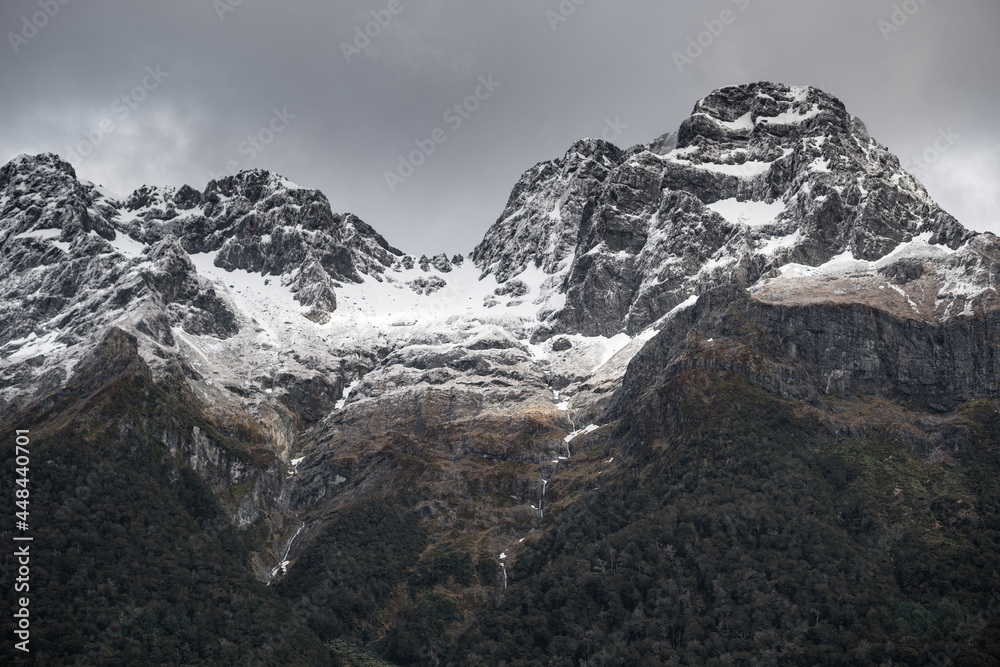 Obraz premium Mirror Lakes are a famous natural landmark omn the Milford Road in the Fiordland National Park. Snowy mountains are reflecting in a calm water. New Zealand