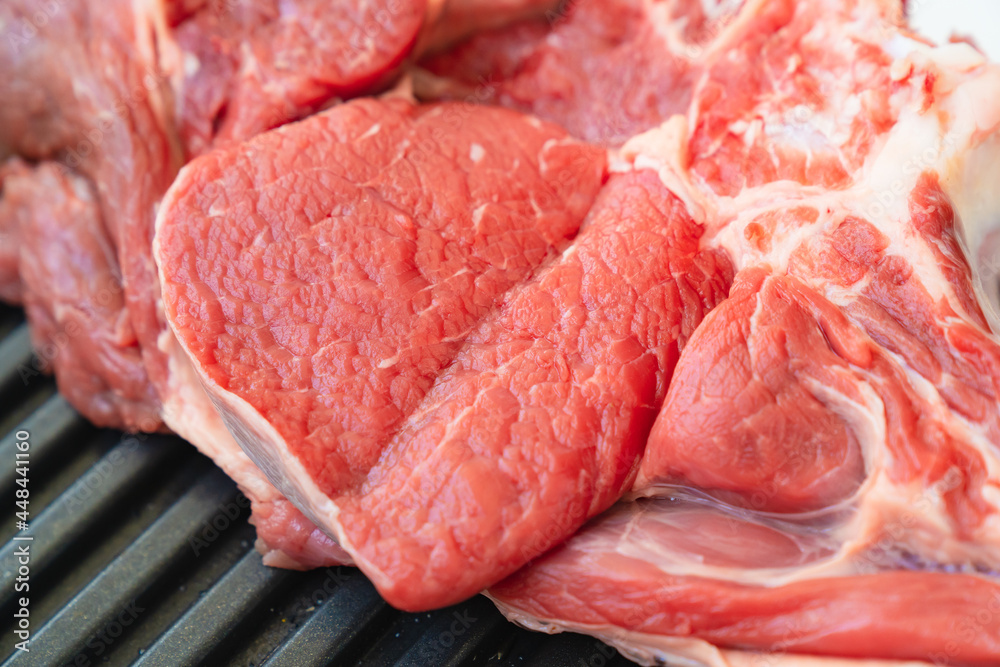piece of beef on bone on black grill pan .natural and eco-friendly farm products piece of beef on bone on black grill pan .natural and eco-friendly farm products