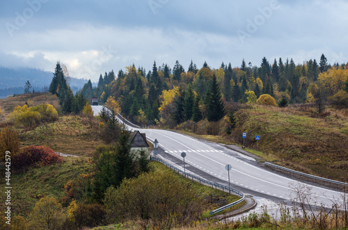 Hazy and overcast Carpathian Mountains and highway on mountain pass, Ukraine.