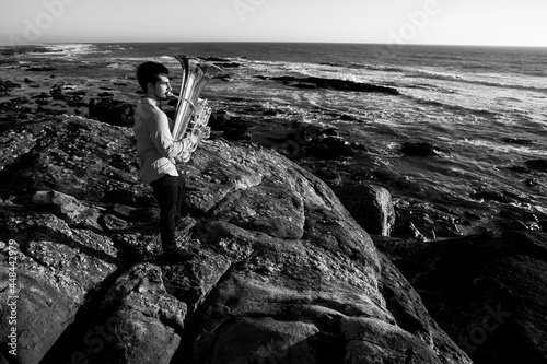 Photography A musician play jazz a tuba on the seashore