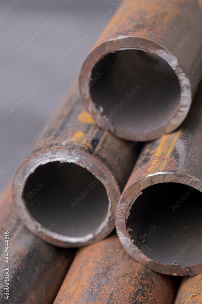 Background of fragments of rusted metal pipes close-up. Industrial abstract background.