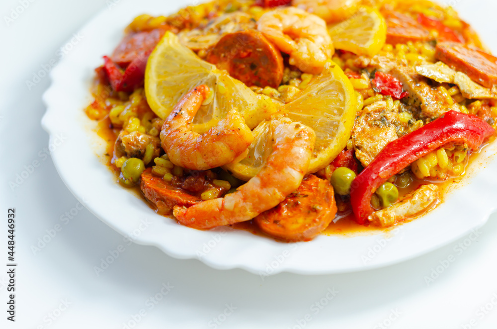 Delicious paella, cooked risotto rice with chicken thigh, king prawns, tomatoes and chorizo Delicious paella, cooked risotto rice with chicken thigh, king prawns, tomatoes and chorizo