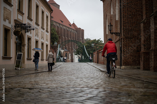 people on the old streets of polish city, rainy day in the city
