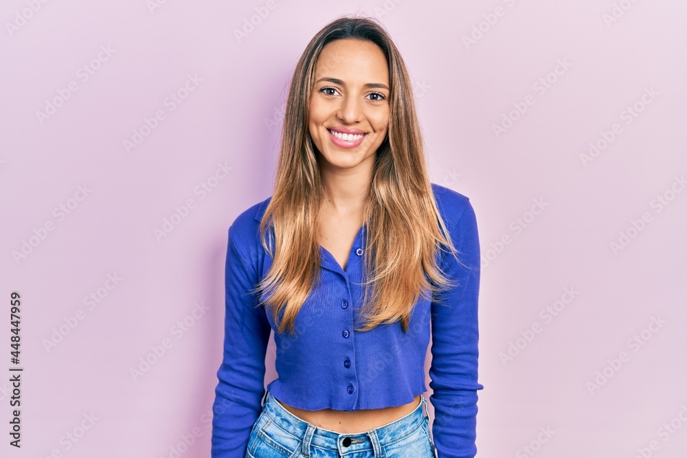 Beautiful hispanic woman wearing casual blue shirt with a happy and cool smile on face. lucky person. Beautiful hispanic woman wearing casual blue shirt with a happy and cool smile on face. lucky person.