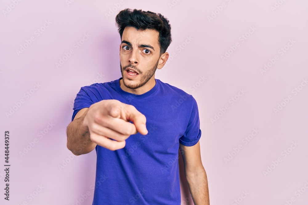 Young hispanic man wearing casual t shirt pointing displeased and frustrated to the camera, angry and furious with you