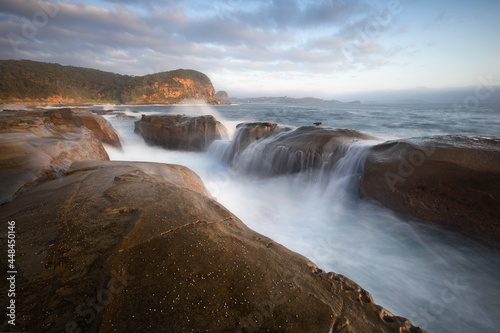 waterfall on the rocks at the beach in the morning glow