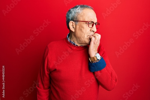 Handsome senior man with grey hair wearing casual clothes and glasses looking stressed and nervous with hands on mouth biting nails. anxiety problem.