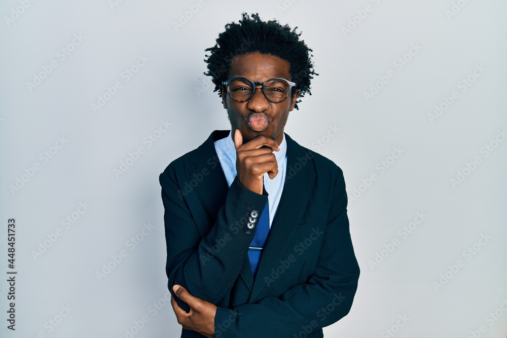 Young african american man wearing business suit and tie looking at the camera blowing a kiss being lovely and sexy. love expression. Young african american man wearing business suit and tie looking at the camera blowing a kiss being lovely and sexy. love expression.