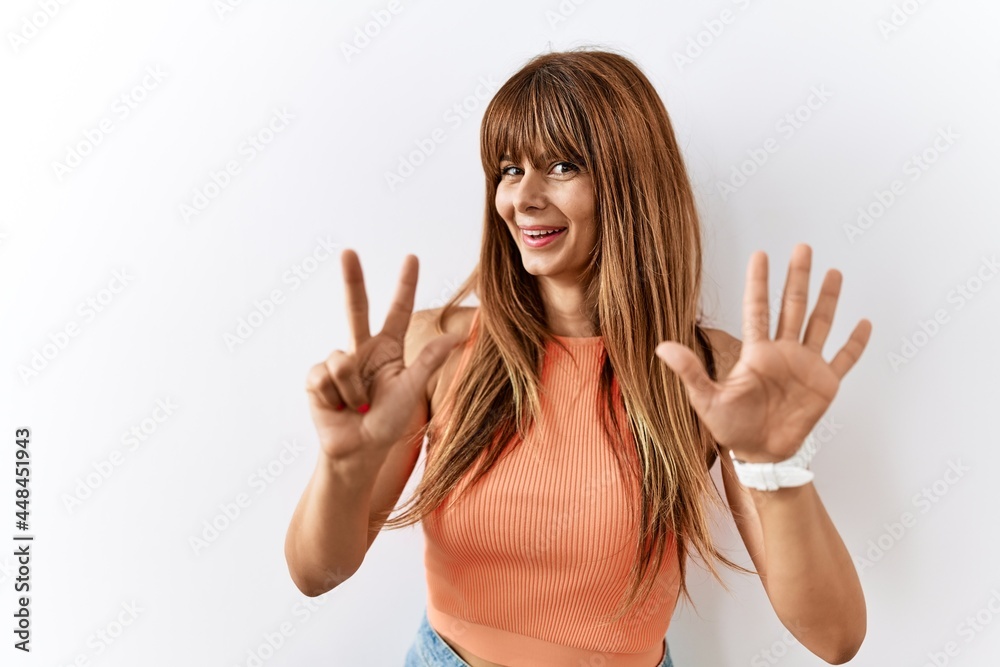 Hispanic woman with bang hairstyle standing over isolated background showing and pointing up with fingers number eight while smiling confident and happy. Hispanic woman with bang hairstyle standing over isolated background showing and pointing up with fingers number eight while smiling confident and happy.