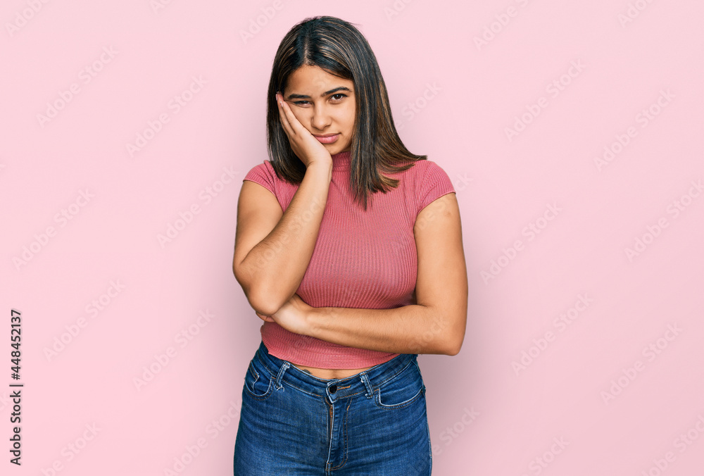 Young hispanic girl wearing casual t shirt thinking looking tired and bored with depression problems with crossed arms. Young hispanic girl wearing casual t shirt thinking looking tired and bored with depression problems with crossed arms.