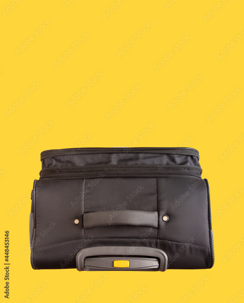 Bright positive minimal travel concept, face looking suitcase isolated on a yellow background with copy space. Luggage case flat lay minimalistic design.