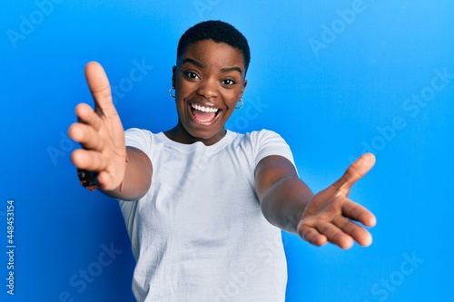 Canvastavla Young african american woman wearing casual white t shirt looking at the camera smiling with open arms for hug