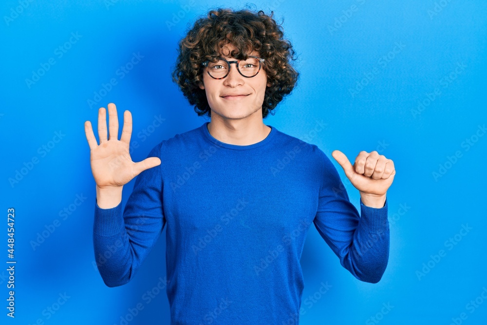 Handsome young man wearing casual clothes and glasses showing and pointing up with fingers number six while smiling confident and happy. Handsome young man wearing casual clothes and glasses showing and pointing up with fingers number six while smiling confident and happy.