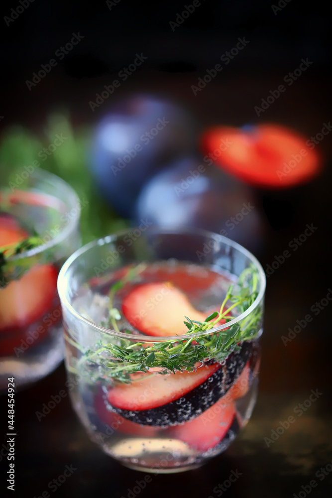 Detox water with plums and thyme. Healthy summer drinks. Refreshing drink with mineral water. The keto diet.