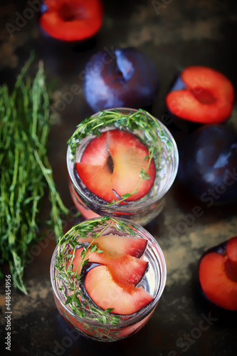Detox water with plums and thyme. Healthy summer drinks. Refreshing drink with mineral water. The keto diet.