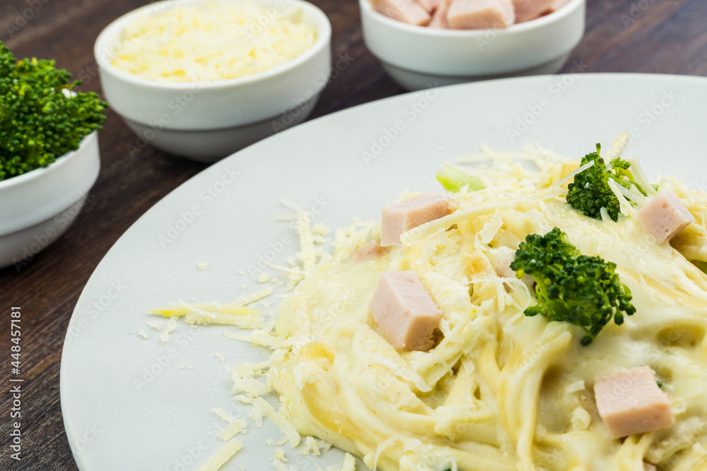 Delicious Fettuccine with white sauce, broccoli, turkey breast cubes and grated cheese. Selective focus. Delicious Fettuccine with white sauce, broccoli, turkey breast cubes and grated cheese. Selective focus.