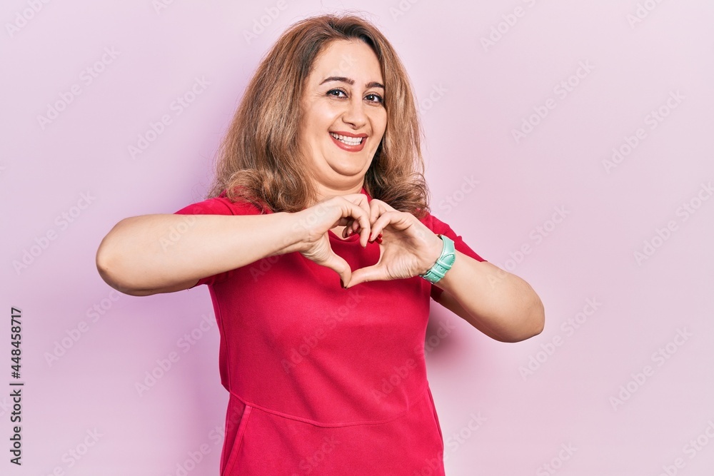 Middle age caucasian woman wearing casual clothes smiling in love doing heart symbol shape with hands. romantic concept. Middle age caucasian woman wearing casual clothes smiling in love doing heart symbol shape with hands. romantic concept.