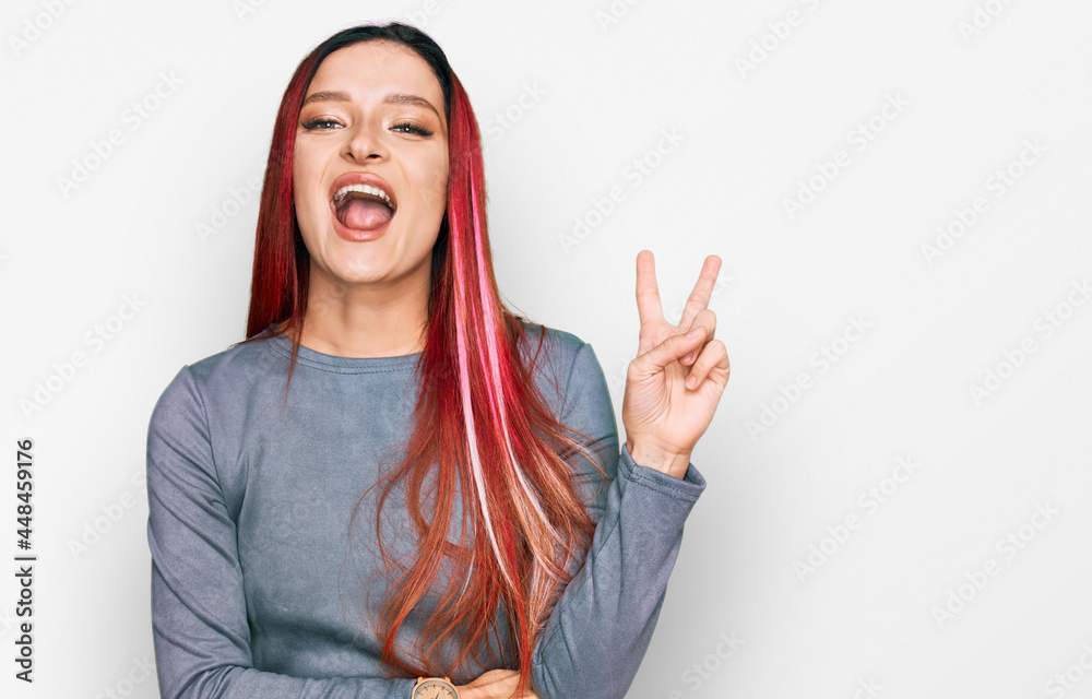 Young caucasian woman wearing casual clothes smiling with happy face winking at the camera doing victory sign. number two. Young caucasian woman wearing casual clothes smiling with happy face winking at the camera doing victory sign. number two.