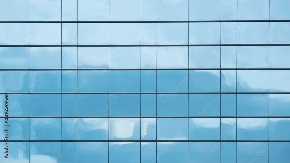Time lapse of blue sky and clouds reflected in structural modular glass wall. Time lapse of blue sky and clouds reflected in structural modular glass wall.