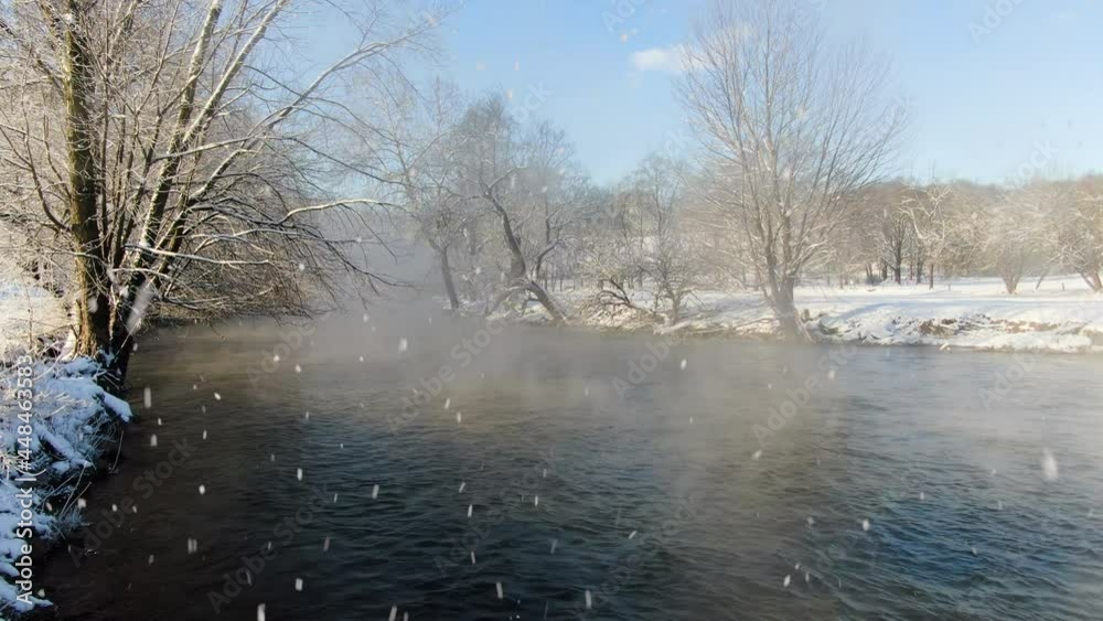 AERIAL Snow Falling Over Cold Misty River, White Ice Covered Banks AERIAL Snow Falling Over Cold Misty River, White Ice Covered Banks