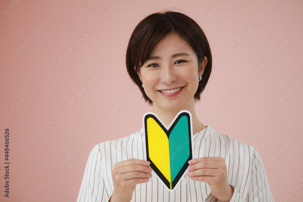 初心者マークを持つ女性 初心者マークを持つ女性