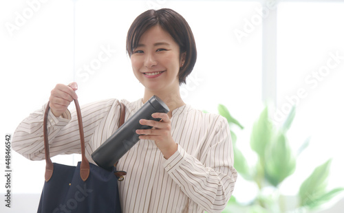 Fotografie 鞄から水筒を取り出す女性