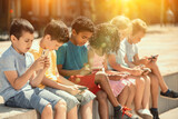 Children chatting on their smartphone, sitting on street parapet