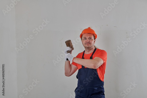 foreman in gloves with a sledgehammer in his hands