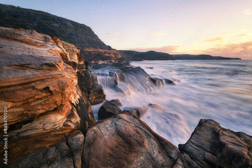 water cascading down the rocks along the coastline