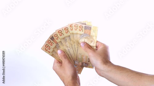 A man showing a range of 50 reais bills on white background photo