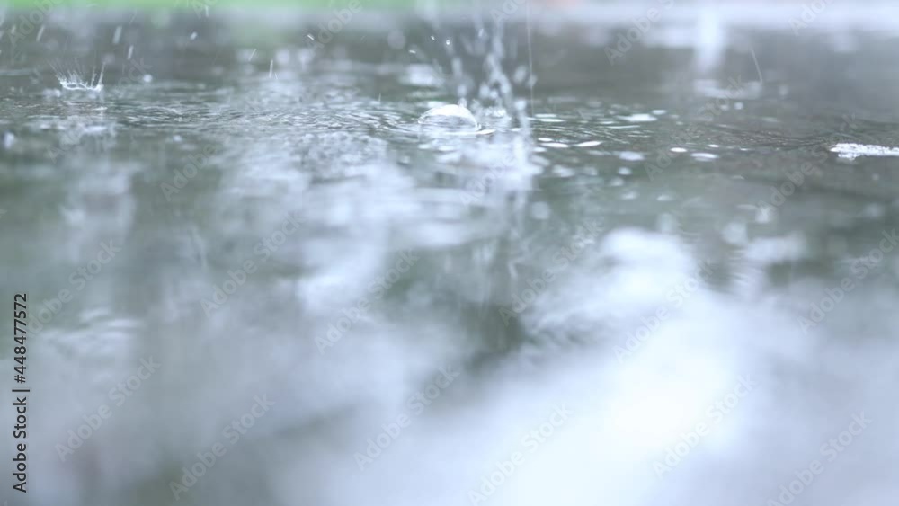 summer rainfall water drops and splashes hit the pavement tile path sidewalk making puddles summer rainfall water drops and splashes hit the pavement tile path sidewalk making puddles