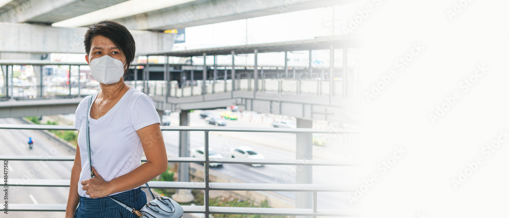 Fototapeta premium Asian woman wearing N95 face mask standing on sky walk during go to work. social distancing, coronavirus, quarantine or new normal concepts