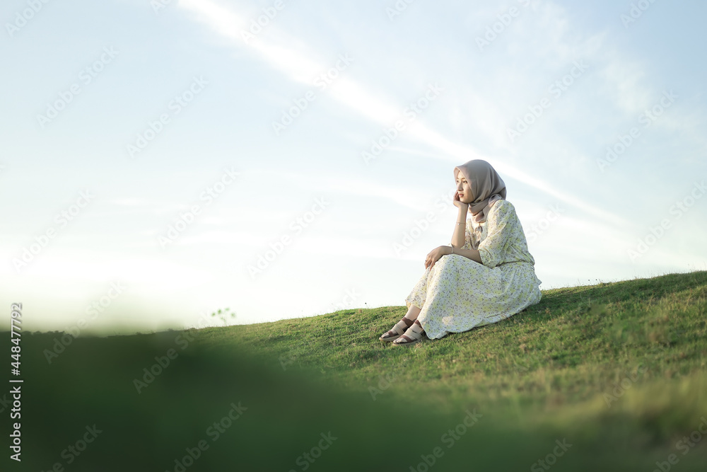 Woman with white dress enjoying the sunset on the grass. Summer vacation at Buffalo Village Woman with white dress enjoying the sunset on the grass. Summer vacation at Buffalo Village