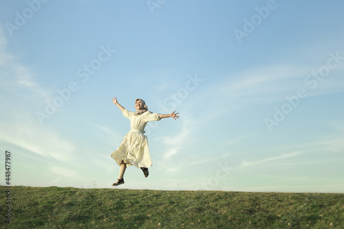Woman with white dress feeling happy on the grass enjoying summer vacation at Buffalo Village
