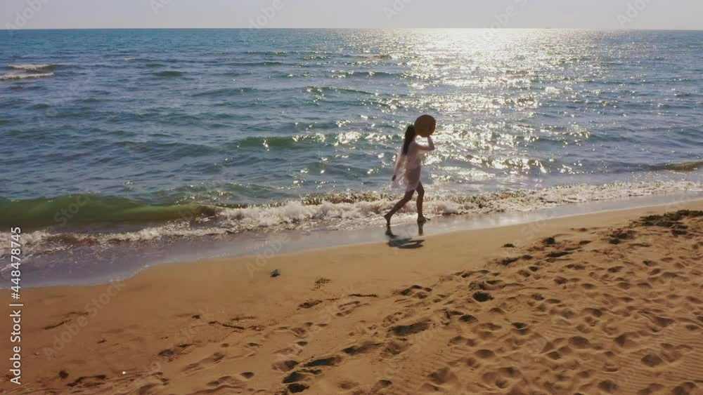 Attractive brunette enjoying sunny day at sea, walking in waves washing sandy beach. Summer vacation at sea concept. Attractive brunette enjoying sunny day at sea, walking in waves washing sandy beach. Summer vacation at sea concept.