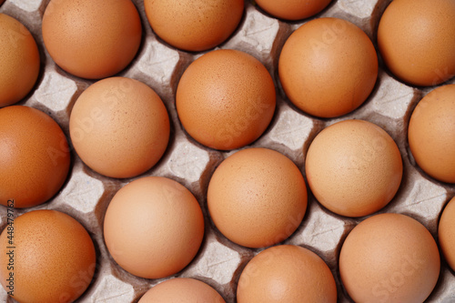 brown chicken eggs in egg carton on background