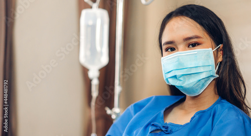 Portrait of asian woman patient sitting on bed wearing protective mask with health medical care express trust and Insurance concept in room at hospital