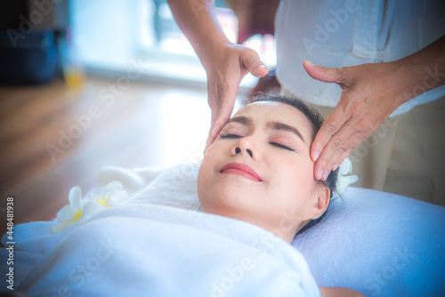 Beautiful woman during facial massage in spa salon, Close up of asian woman. She is feeling relax and happy.