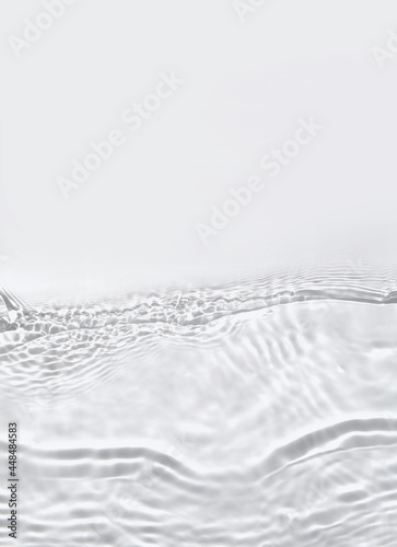 Transparent water surface with ripples and splashes. Summer water waves background in sunlight. copy space