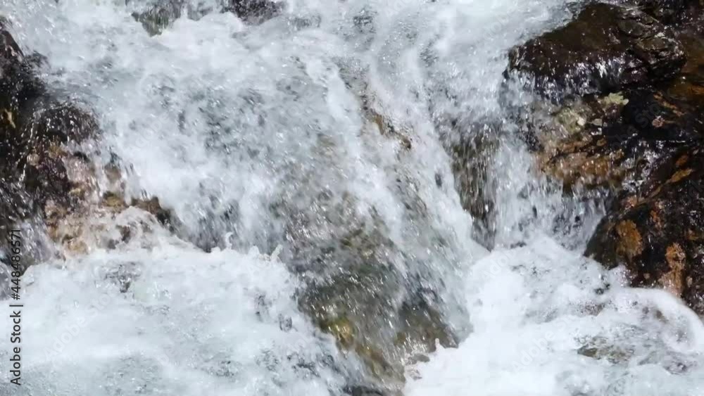 Wild mountain river. A stream with clear clear water and boulders close-up. Slow motion Wild mountain river. A stream with clear clear water and boulders close-up. Slow motion