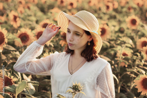 a young girl in a white dress among sunflower flowers