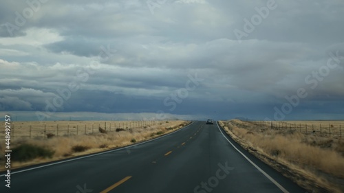 Driving auto, road trip in California, USA, view from car. Hitchhiking traveling in United States. Highway, mountains and cloudy dramatic sky before rain storm. American scenic byway. Passenger POV.